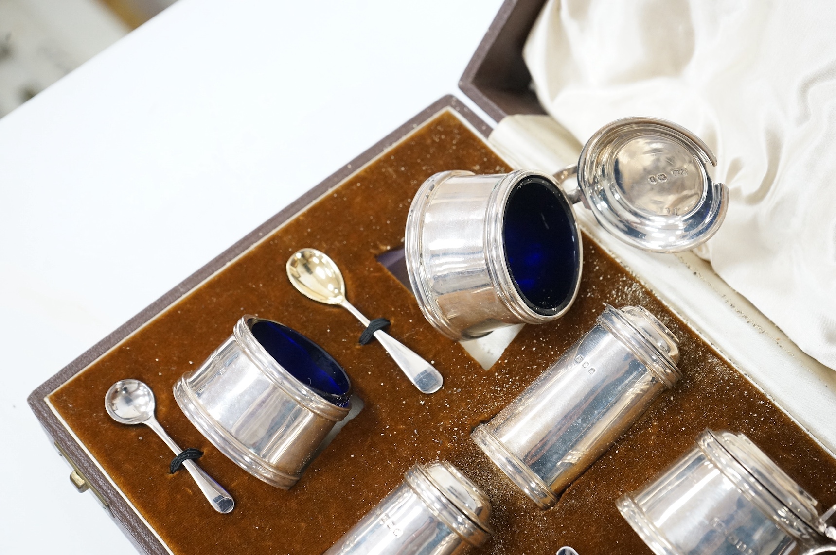 A cased George V silver six piece condiment set, by Josiah Williams & Co, with four later associated silver condiment spoons. Condition - fair